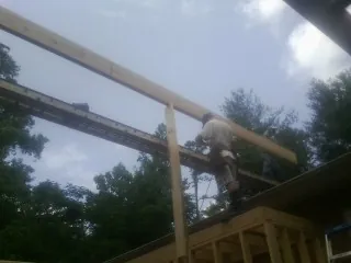 Carpenter setting a ridge beam over a new addition frame — Ice Dam Removal by Roofing Brothers in East Greenbush