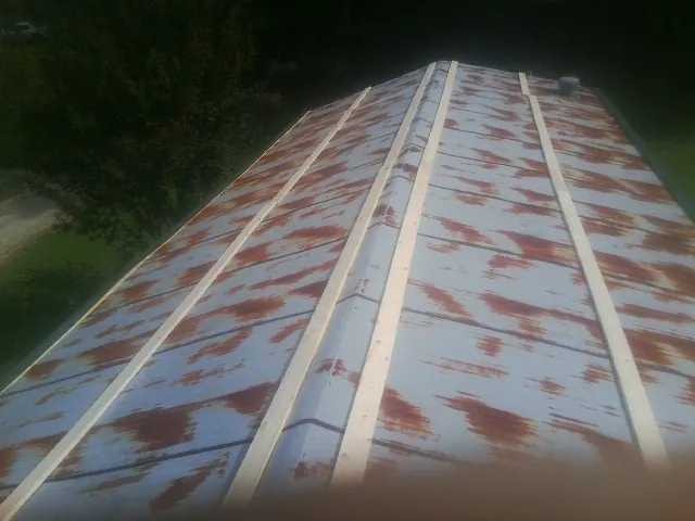 Rusted metal roof panels with new wood purlins before replacement — Storm Damage Roof Repair in East Greenbush by Roofing Brothers