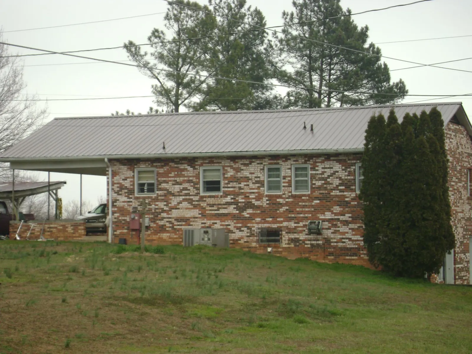 Gray metal roof on a brick split level home with a carport in East Greenbush