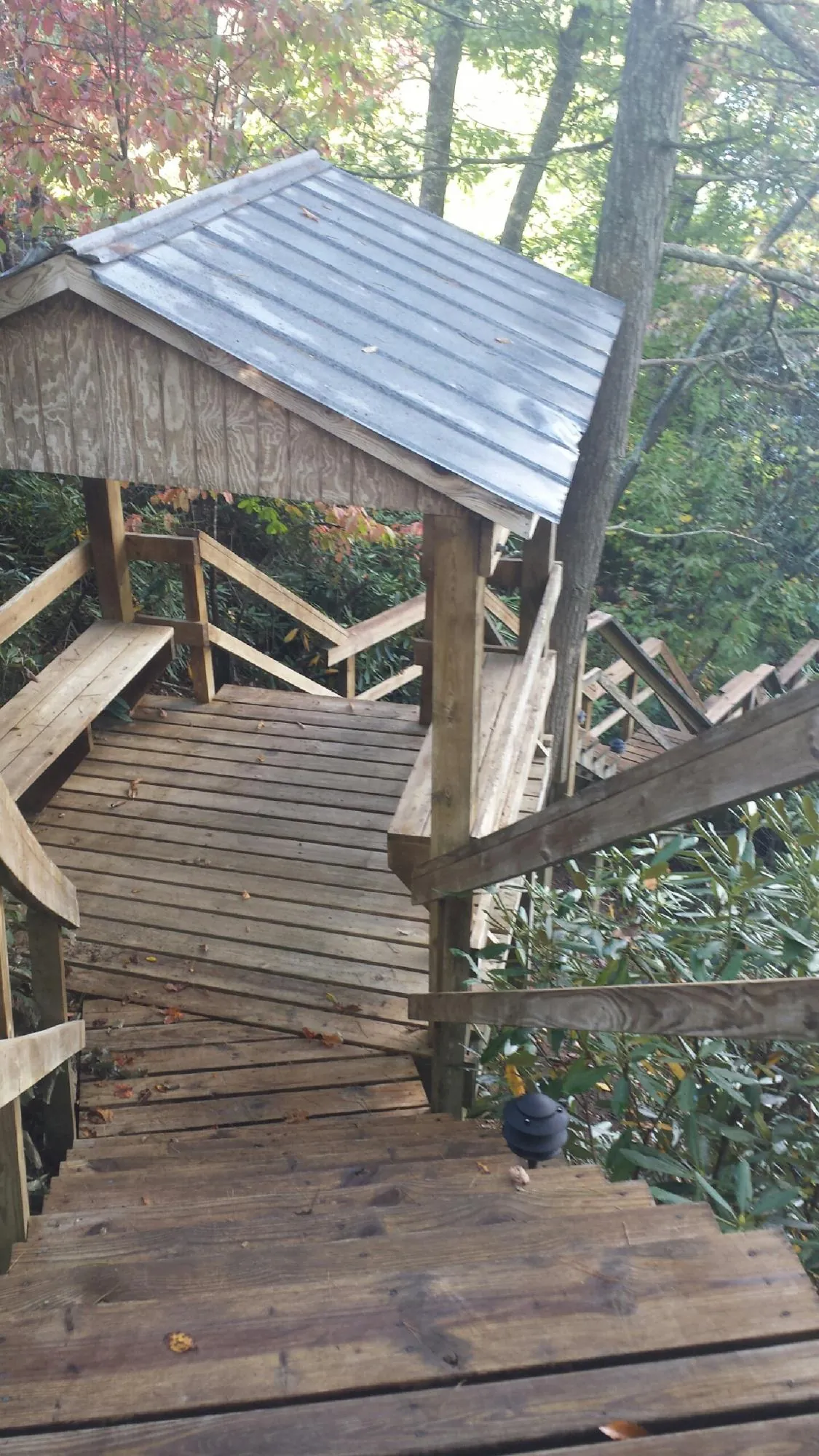 Metal roofed shelter over wooden steps on a wooded walkway — Skylight Repair & Installation work by our crew in East Greenbush
