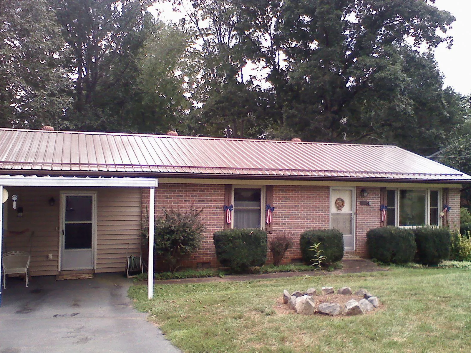 Bronze metal roof and carport on a brick ranch home — Roof Repair work by our crew in East Greenbush